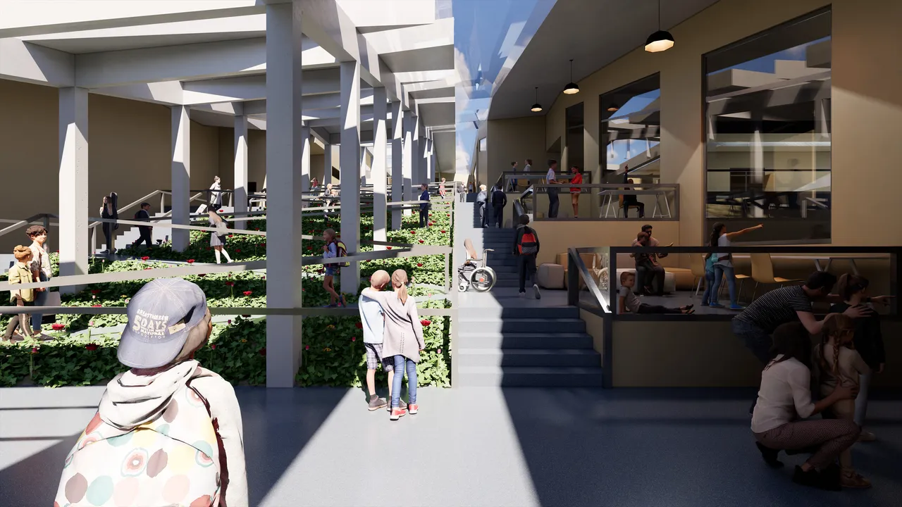 A daylit interior street inside the school. A run of slender columns carries a glazed roof over a long planted bed of red flowers, with tiered seating and glazed classrooms on the right and children moving along both edges.